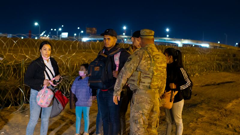 Migrants are stopped by a Texas National Guard soldier after crossing from Ciudad Juarez,...