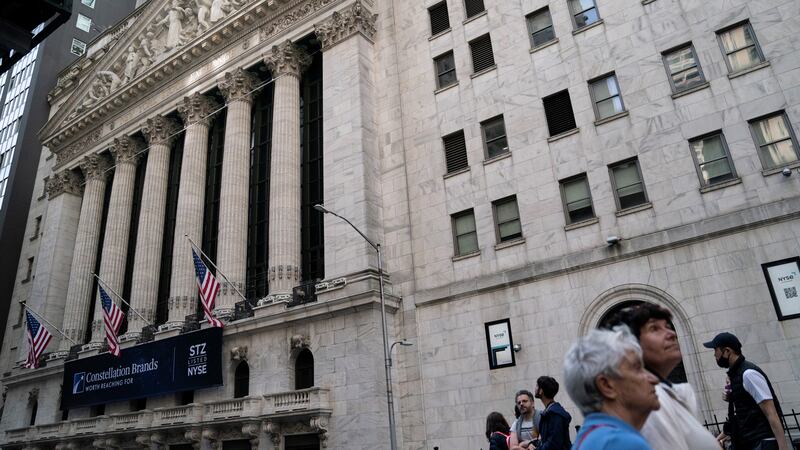 FILE - Pedestrians pass the New York Stock Exchange, Thursday, May 5, 2022, in the Manhattan...
