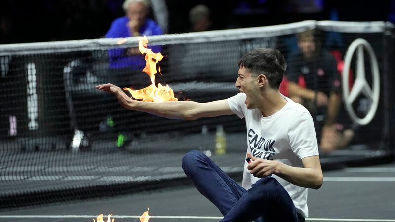 A man sets fire on his hand during protest at a match Team World's Diego Schwartzman against...