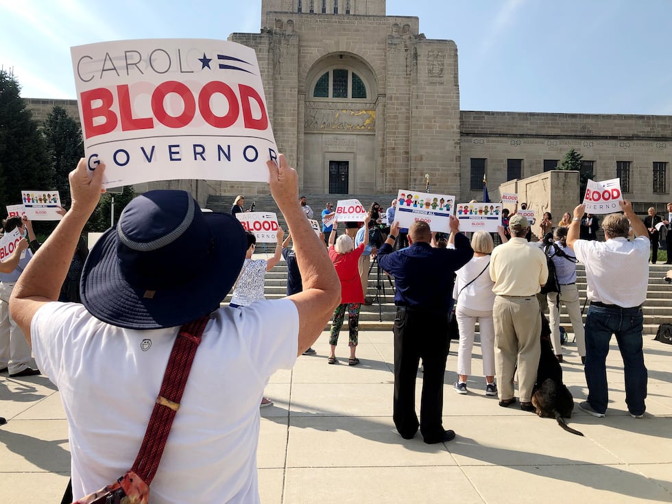 Supporters hold up signs as State Sen. Carol Blood announces her run for governor on Monday,...