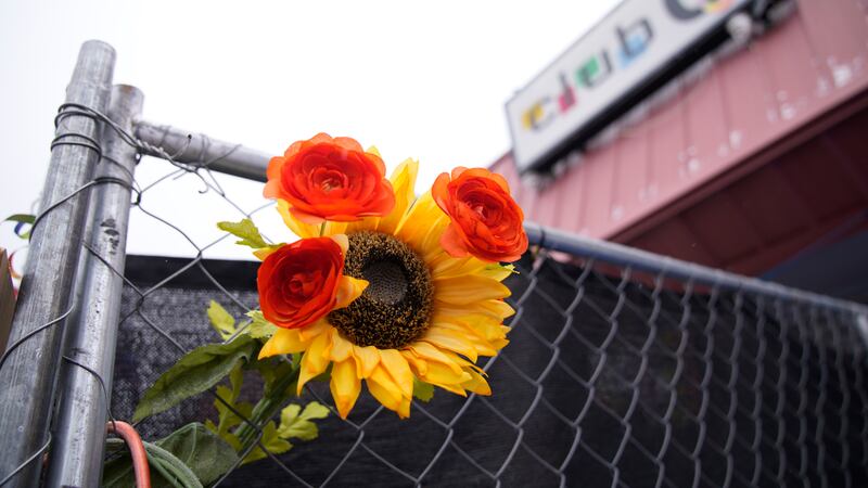A tribute is placed in a fence of Club Q, which was the site of a mass shooting in November...