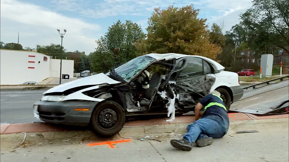 A tow truck driver prepares to haul away a vehicle involved in a crash at 68th and Dodge...