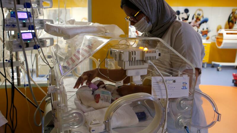 A Moroccan nurse takes care of one of the nine babies protected in an incubator at the...