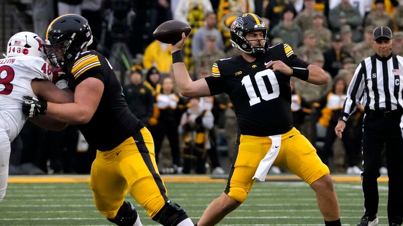 Iowa quareterback Deacon Hill (10) looks to throw a pass against Rutgers during the first...