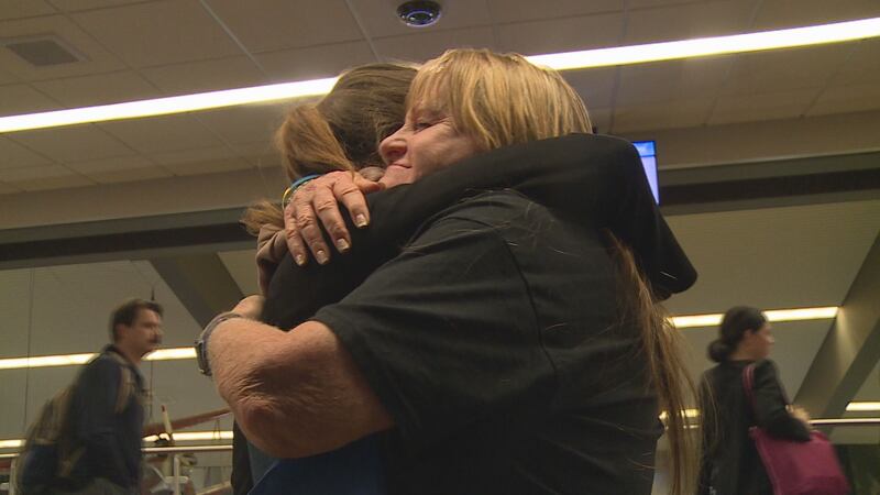 Penne Hanus embraces Margo Shevchenko, a Ukrainian refugee, at the Lincoln Airport