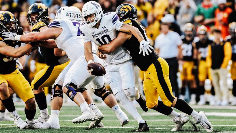 Iowa Hawkeyes defensive end Joe Evans, right, sacks Northwestern quarterback Brendan Sullivan...