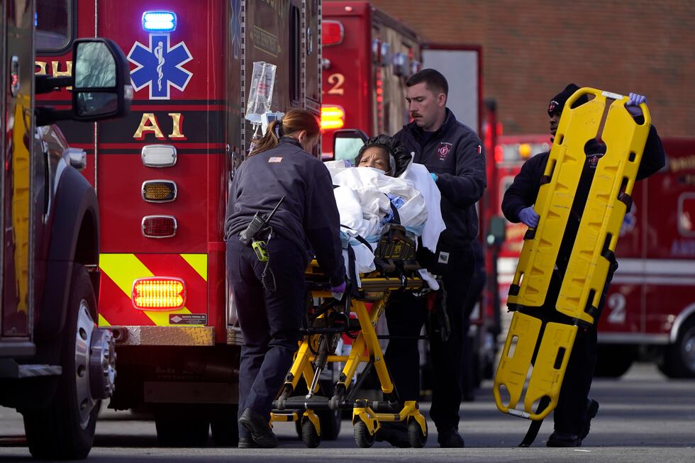 A patient, center, is placed into an ambulance while being evacuated from Signature Healthcare...
